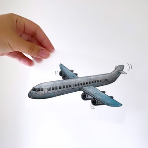 Peut inclure: Une illustration de dessin animé d'un avion gris avec des accents bleus. L'avion a un visage souriant et vole avec ses ailes inclinées vers le haut.