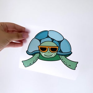 Peut inclure: Une illustration de dessin animé d'une tortue portant des lunettes de soleil orange. La tortue a une carapace bleue avec des pattes vertes et une tête verte.