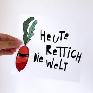 Könnte beinhalten: Eine weiße Karte mit einem roten Rettich, der eine schwarze Augenmaske trägt und den Text "Heute Rettich die Welt" in Schwarz.