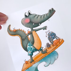 Könnte beinhalten: Ein grünes Krokodil, das blaue und weiße Blumen-Badehosen trägt, surft auf einem gelben Surfbrett. Das Krokodil hat einen rosa Rouge auf den Wangen und lächelt. Auf dem Surfbrett befinden sich drei kleine orangefarbene Krabben und ein blauer Tintenfisch mit einem weißen Matrosenhut sitzt auf der Rückseite des Surfbretts.