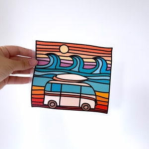 Könnte beinhalten: Eine Illustration im Retro-Stil eines weißen Vans mit einem Surfbrett auf dem Dach, der an einem Strand mit Wellen und einem Sonnenuntergang im Hintergrund fährt. Der Van hat eine blaue Karosserie, orangefarbene Räder und einen roten Streifen.