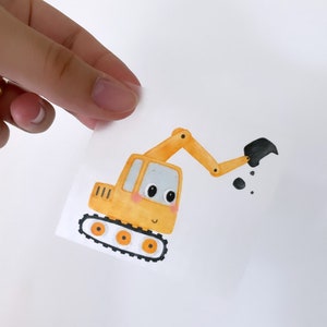 May include: A yellow cartoon excavator with a black bucket and black tracks. The excavator has a smiling face with black eyes and a small red blush on each cheek.