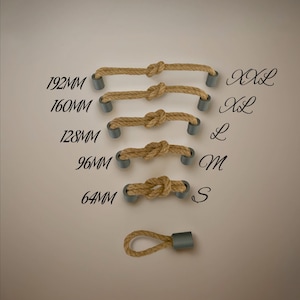 Può includere: Cinque maniglie in corda di diverse lunghezze, etichettate S, M, L, XL e XXL. Le maniglie sono in corda naturale con un nodo al centro e terminali in metallo grigio. La maniglia più piccola è lunga 64 mm, la più grande 192 mm.