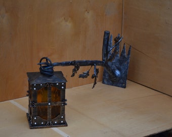 Forged street sconce in the form of an oak branch with a lantern