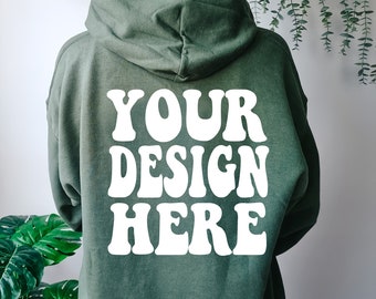 May include: A green hooded sweatshirt with the text "YOUR DESIGN HERE" in white on the back.