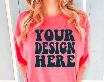 May include: A pink oversized t-shirt with the text "YOUR DESIGN HERE" in black retro-style lettering.