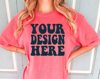 May include: A pink oversized t-shirt with the text "YOUR DESIGN HERE" in black retro-style lettering.