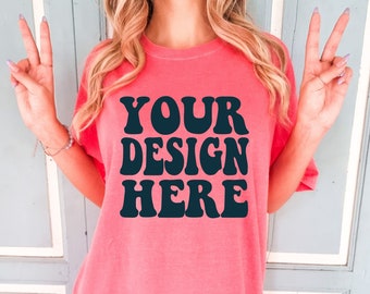 May include: A pink oversized t-shirt with the text "YOUR DESIGN HERE" in black retro-style lettering.