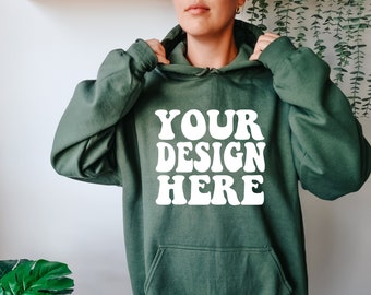 May include: A green hooded sweatshirt with the text "YOUR DESIGN HERE" in white retro-style lettering.