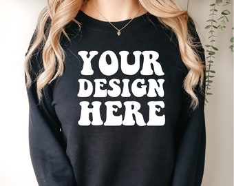 Puede incluir: Sudadera negra con el texto "YOUR DESIGN HERE" en blanco, en una fuente de estilo retro.