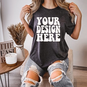 May include: A dark gray t-shirt with the text "YOUR DESIGN HERE" in white retro-style lettering.