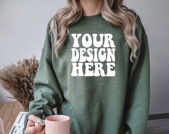 Op de afbeelding: Een groen sweatshirt met de tekst "YOUR DESIGN HERE" in witte retro-letters.