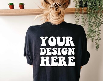 Pode incluir: Camiseta preta com texto branco que diz "YOUR DESIGN HERE" em uma fonte retrô.