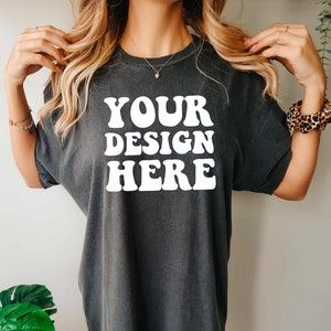 May include: A dark gray oversized t-shirt with the text "YOUR DESIGN HERE" in white.