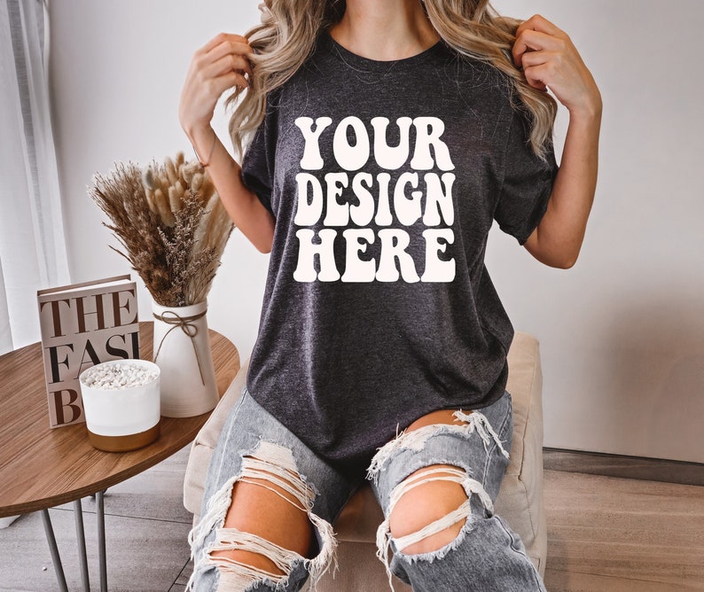 May include: A dark gray t-shirt with the text "YOUR DESIGN HERE" in white retro-style lettering.