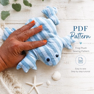 Könnte beinhalten: Ein handgefertigtes Frosch-Plüschtier aus blau-weiß gestreiftem Stoff. Der Frosch hat Wackelaugen und ist Teil eines PDF-Schnittmusters. Das Bild enthält den Text "PDF Pattern" und "Frog Plush Sewing Pattern".
