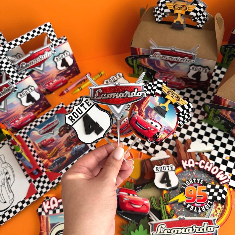 Pode incluir: Um conjunto de decora&ccedil;&otilde;es para festas com um carro de corrida vermelho, uma bandeira quadriculada e uma placa que diz "Rota 4". As decora&ccedil;&otilde;es s&atilde;o perfeitas para uma festa de anivers&aacute;rio com tema Cars.