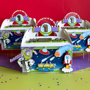 May include: Toy Story party favour boxes. Each box features Buzz Lightyear, aliens, a rocket, and a space scene. The boxes have a handle and the text "TO INFINITY & BE ONE" and "JAI SEO JUN".