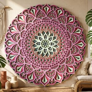K&ouml;nnte beinhalten: Ein gro&szlig;es, mehrschichtiges Mandala-Wandkunstwerk aus Holz. Das kreisf&ouml;rmige Design weist komplizierte Muster in Rosa-, Gr&uuml;n-, Schwarz- und Wei&szlig;t&ouml;nen auf. Das Kunstwerk ist an einer neutralfarbenen Wand angebracht, mit einem Makramee-Wandbehang und Pflanzen im Hintergrund.
