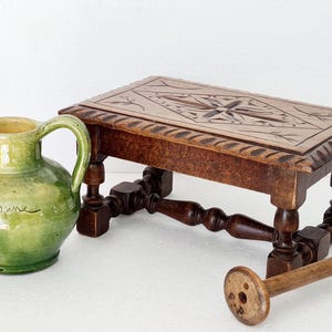 Vintage footstool in carved oak wood, country house style.