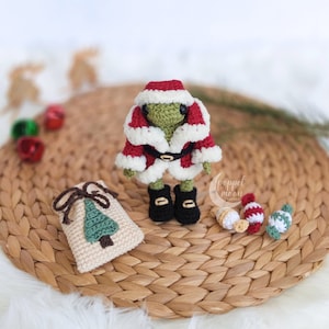 May include: Crocheted Christmas outfit for a small stuffed animal, featuring a red and white Santa suit, a black belt, black boots, a small sack with a green tree, and candy canes.  Outfit & Accessories Only (Frog Pattern NOT Included).