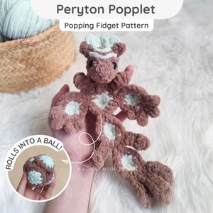 Puede incluir: Un juguete fidget Peryton Poppet de ganchillo en color marrón y verde menta con un diseño de criatura alada plana que se enrolla en una bola. El texto Peryton Poppet Popping Fidget Pattern y ROLLS INTO A BALL! son visibles en la imagen.