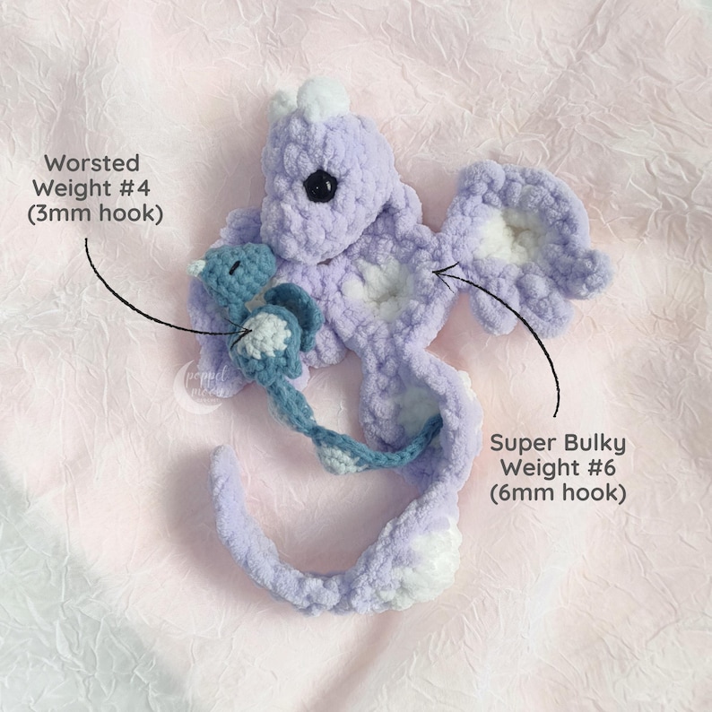 May include: A handmade crochet seahorse in shades of lavender and white, with a smaller blue seahorse attached. The text indicates the use of Worsted Weight #4 yarn with a 3mm hook and Super Bulky Weight #6 yarn with a 6mm hook.