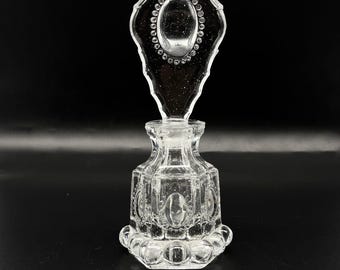 Frasco de perfume y tapón de vidrio prensado con medallón y cuentas de L E Smith, década de 1940.