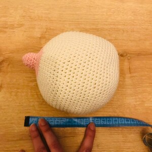 Peut inclure: Une boule en crochet blanc avec un patch en crochet rose sur un c&ocirc;t&eacute;. La boule mesure environ 43 cm de diam&egrave;tre.