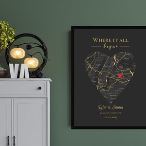 May include: Black and gold framed print with a heart-shaped map of a city. The text "Where it all began" is at the top of the print. The names "Tyler & Emma" and a date are at the bottom of the print.