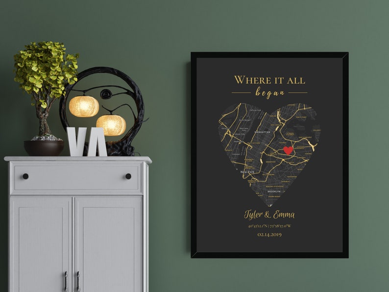 May include: Black and gold framed print with a heart-shaped map of a city. The text "Where it all began" is at the top of the print. The names "Tyler & Emma" and a date are at the bottom of the print.