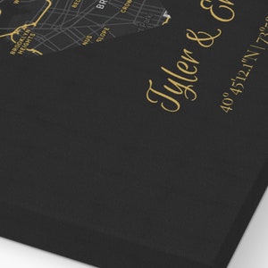 May include: A black and gold map of New York City with the text "Tyler & Emily" and the coordinates "40&deg;45'12.1"N | 73&deg;58'57.0" and the date "02.14.2010".