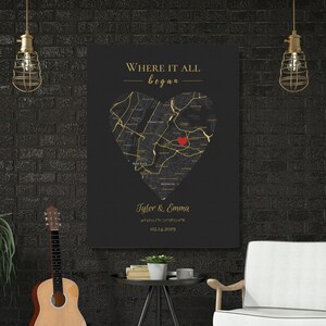 May include: A black and gold canvas print with a heart-shaped map of a city. The text "Where it all began" is at the top of the print. The names "Tyler & Emma" and a date are at the bottom of the print.