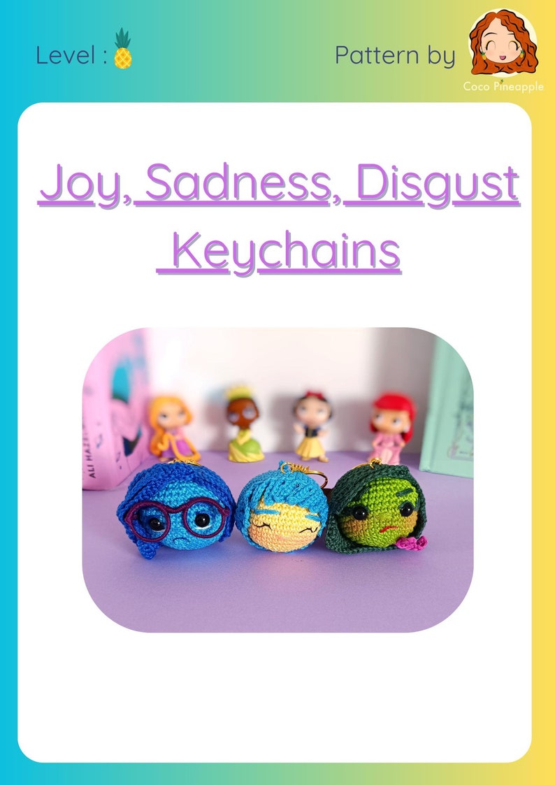 May include: Three crocheted keychains of the characters Joy, Sadness, and Disgust from the movie Inside Out. The keychains are on a purple surface. The text "Joy, Sadness, Disgust Keychains" is at the top of the image.