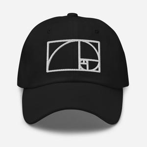 May include: A black baseball cap featuring a white embroidered design of the golden ratio spiral on the front panel. The cap has a structured crown, a curved brim, and a button on top, showcasing a clean and simple aesthetic for headwear.