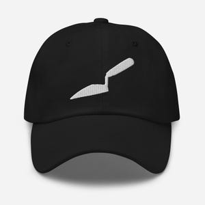 Peut inclure: Une casquette de baseball noire avec une broderie blanche représentant une truelle de maçon centrée sur le panneau avant. La casquette présente une visière incurvée, une calotte structurée et un bouton sur le dessus, au design épuré.