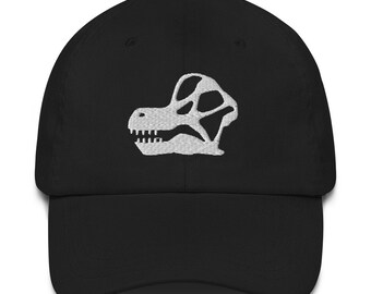 May include: A black baseball cap with a white embroidered dinosaur skull design.