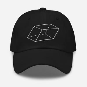 Puede incluir: Una gorra de béisbol negra con un gráfico bordado en blanco de una forma geométrica de paralelepípedo. El diseño consiste en líneas sólidas y discontinuas que forman una estructura de caja tridimensional en el panel frontal.
