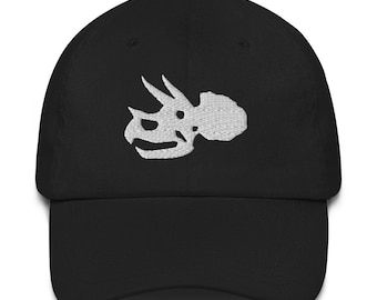 May include: A black baseball cap with a white embroidered dinosaur skull on the front.