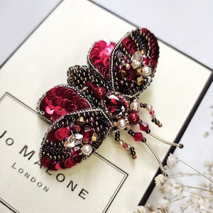 Broche de mariposa feito à mão com contas: cristal vermelho e lantejoulas