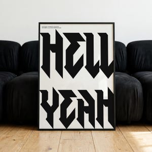 Può includere: Un poster verticale incorniciato con una tipografia nera audace su sfondo bianco. Il testo recita HELL YEAH in un carattere gotico dai tratti angolari e netti. Un piccolo testo di copyright è visibile nell'angolo in alto a sinistra.