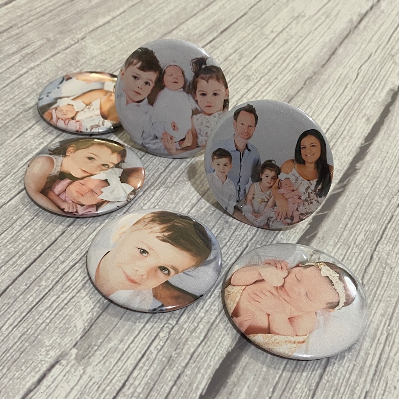 May include: Set of 7 round photo buttons with various images of families and children. The buttons are white with a glossy finish.