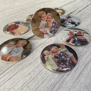 May include: A set of six round button pins featuring photos of families. The photos show a variety of family members, including parents and children. The buttons are a great way to show off your family photos and add a personal touch to your belongings.