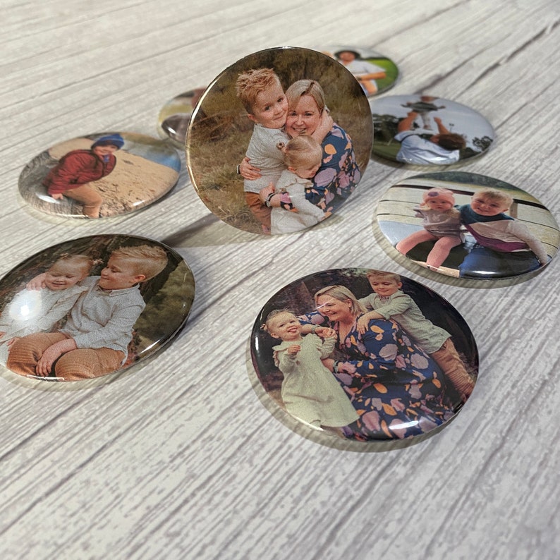 May include: A set of six round button pins featuring photos of families. The photos show a variety of family members, including parents and children. The buttons are a great way to show off your family photos and add a personal touch to your belongings.