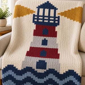 May include: A chunky knit throw blanket featuring a central lighthouse design in dark blue, red, and light gray, set against a cream background. The base displays wavy dark blue and light blue stripes, with yellow beams of light extending outward.
