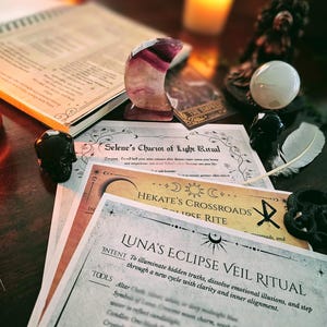 May include: A collection of spiritual tools and ritual guides, including a crescent-shaped crystal, a white sphere, and printed ritual instructions. The guides include titles like "Selene's Chariot of Light Ritual" and "Luna's Eclipse Veil Ritual."