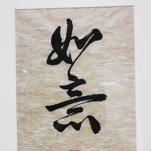 Może przedstawiać: Ramka z czarno-białym dziełem kaligraficznym na beżowym tle z czerwoną pieczęcią. Kaligrafia jest w chińskich znakach.