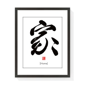 May include: Black and white calligraphy art print of the Chinese character for "home" in a black frame. The character is written in a bold, brushstroke style. The print includes a red seal with the word "home" in English below the character.