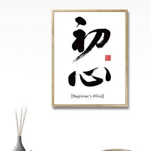 Pu&ograve; includere: Stampa d'arte calligrafica in bianco e nero in una cornice di legno con i caratteri giapponesi per "Beginner's Mind" scritti in inchiostro nero. Il testo "[Beginner's Mind]" &egrave; scritto in nero sotto la calligrafia.