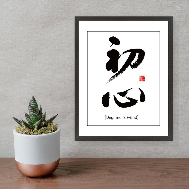 Pu&ograve; includere: Stampa d'arte calligrafica in bianco e nero in una cornice nera con la parola giapponese "初心" (Shoshin) che significa "Mente del principiante".